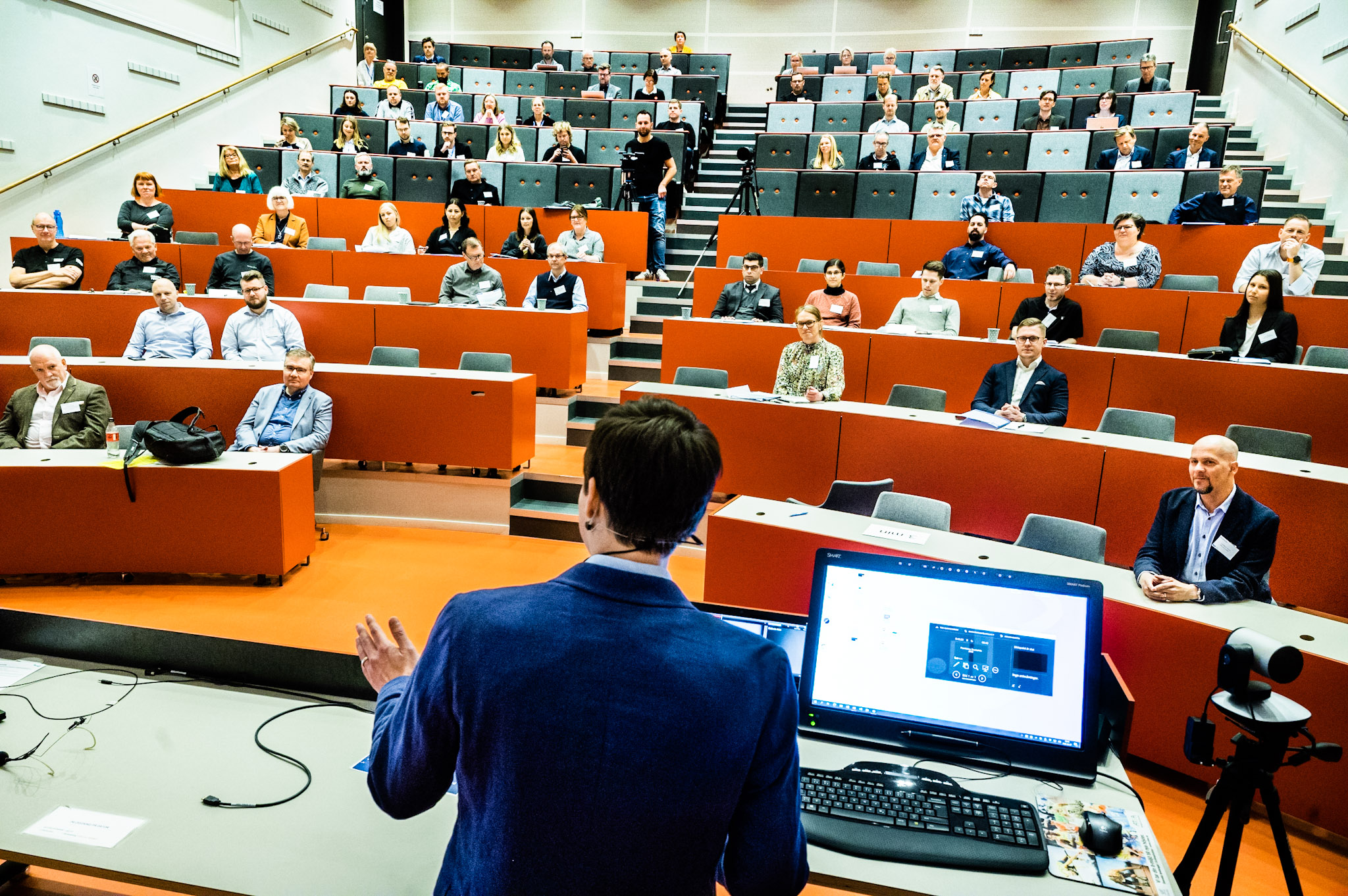 The editor introduces speakers in the main hall during the 2022 conference